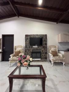 a living room with a fireplace and a table with flowers at new vintage penthouse in Bhowāli