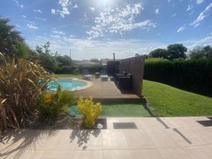 a backyard with a swimming pool and a deck at CHAMBRE D HÔTE CHEZ Nath in Sadirac