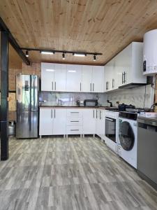 a kitchen with white cabinets and a wooden ceiling at Vista Adishi in Adishi