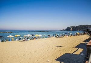 a group of people on a beach with umbrellas at Little House Forio in Forio d'Ischia