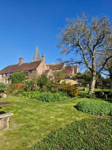 a park with a building and a tree and grass at 'Little Star' accommodation in Heathfield
