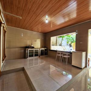 a large kitchen with a wooden ceiling at Rian Kost - Hotel Penginapan Murah Pusat Kota Palembang in Palembang