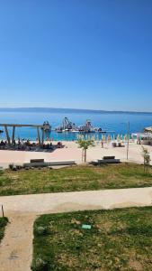 a beach with people on the sand and the ocean at Apartments Deja Views - Žnjan beach in Split