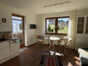 a kitchen and living room with a table and a window at Ferienwohnung Krokus in Weiler-Simmerberg