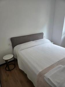 a bedroom with two beds and a stool next to a bed at Pasaje Plaza Apartamento in Alcazar de San Juan