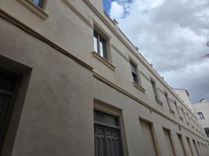 a large white building with windows and a door at Pasaje Plaza Apartamento in Alcazar de San Juan