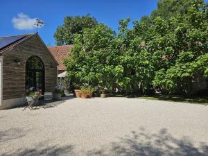 a church with a gravel driveway in front of a building at Casa Leone near Bruges with jacuzzi & parking in Ruddervoorde