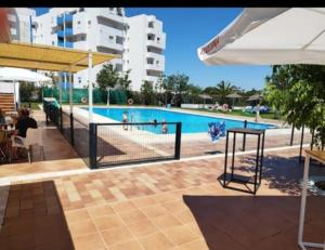 a swimming pool with a fence around it with people in it at Estudio DUNA BLANCA in Matalascañas