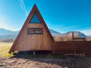 a cabin with a triangular roof with mountains in the background at Ben Nevis Basecamp in Torlundy