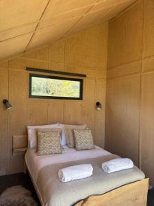 a bed in the center of a room with a window at Ben Nevis Basecamp in Torlundy +21 photos
