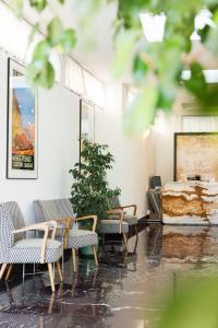 ein Zimmer mit Stühlen, einer Pflanze und einem Gemälde in der Unterkunft Hotel Rio Muralto in Locarno