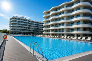 a swimming pool in front of a large apartment building at PEARL COAST Luxury Rogowo Pool Beach in Rogowo