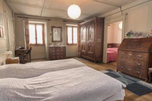 a bedroom with a large bed and a dresser at Appartement ambiance vieux chalet in Sembrancher