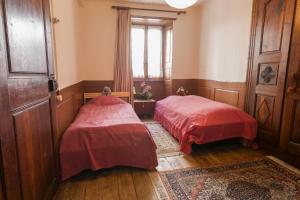 two beds in a small room with a window at Appartement ambiance vieux chalet in Sembrancher