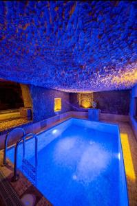 a swimming pool in a room with a fish ceiling at Cappadocia Alfa Cave Hotel in Ürgüp