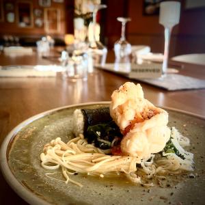 a plate of pasta and vegetables on a table at Wandering Trout in Mole Creek