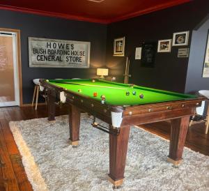 a green pool table in a room with a sign at Wandering Trout in Mole Creek +4 photos