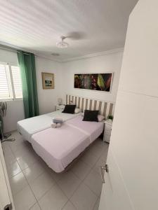 a bedroom with two beds with white sheets and green curtains at Alma&Mateo in El Moncayo