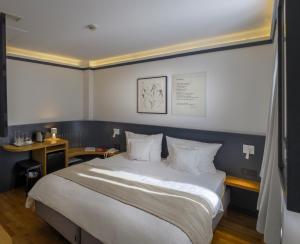 una camera da letto con un grande letto bianco e una scrivania di Hotel Simoncini a Lussemburgo
