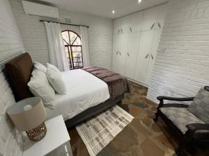 a white bedroom with a bed and a couch at 19 on Amber in Ugie