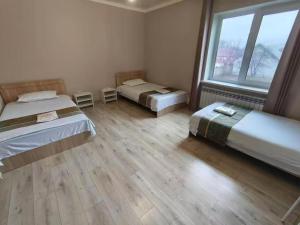 a room with two beds and a large window at Minsu in Mamyr