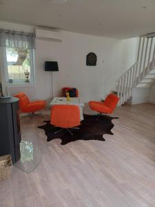 a living room with orange chairs and a table at Önnestad guest house in Önnestad