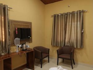 a room with two chairs and a desk and a mirror at Veranda hillside retreat in Kharakvasla