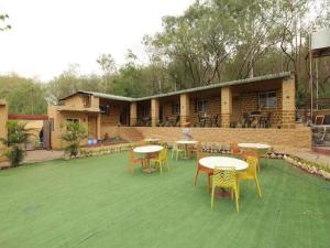 a patio with tables and chairs and a building at Veranda hillside retreat in Kharakvasla