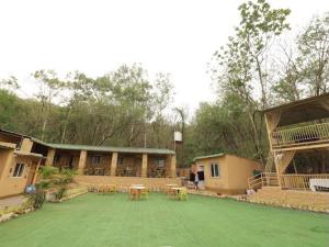 a large yard with tables and chairs in front of a building at Veranda hillside retreat in Kharakvasla