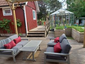 a patio with a couch and a table and a greenhouse at Önnestad guest house in Önnestad