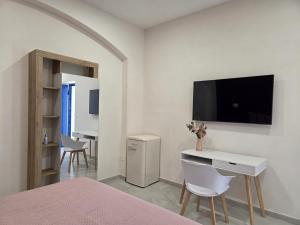 a bedroom with a bed and a desk and a tv at Suite in centro in Aversa