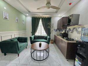 a living room with two green chairs and a table at Gulberg Greens Islamabad in Islamabad