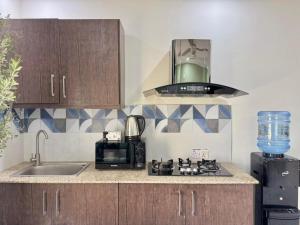 a kitchen with a sink and a stove and a microwave at Gulberg Greens Islamabad in Islamabad