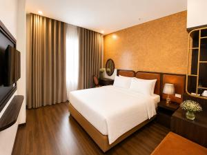 a hotel room with a bed and a television at Valoria Premium Hanoi Hotel and Travel in Hanoi