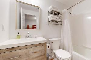 a bathroom with a sink and a toilet and a mirror at Windsor Hill Condo in Waterville Valley +73 photos