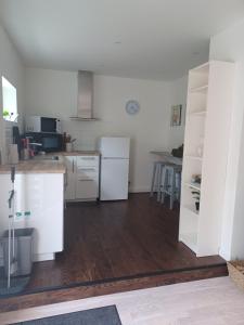 a kitchen with white appliances and a wooden floor at Önnestad guest house in Önnestad