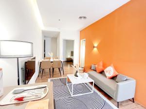 a living room with a couch and an orange wall at Bangsar Trade Centre By WeCare in Kuala Lumpur +145 photos