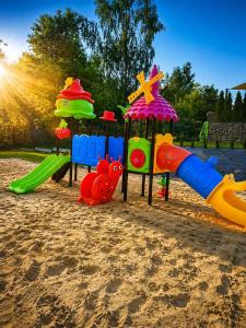 a playground with different types of play equipment in the sand at VeloDomki Żywiec - domki nad Jeziorem Żywieckim in Żywiec