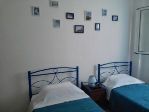 duas camas num quarto com fotografias na parede em Cosy Apartment Pinotsi em Atenas