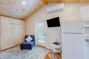 a living room with a refrigerator and a chair at Shorebreeze Inn in Kennebunk