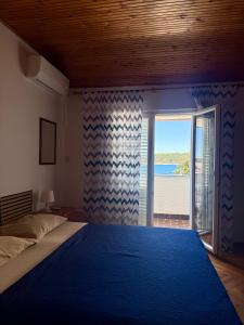 a bedroom with a bed and a view of the ocean at SEA VIEW STUDIO with kitchen, balcony& aircon in Barbat na Rabu