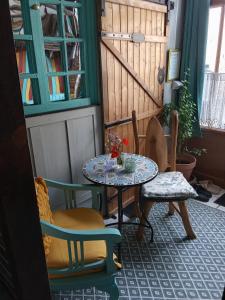 a room with a table and chairs and a window at Room - Les loups bleus in Rossillon