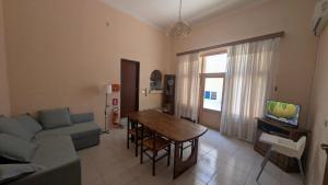 a living room with a couch and a table and a tv at Casa Aranci in Cattolica Eraclea