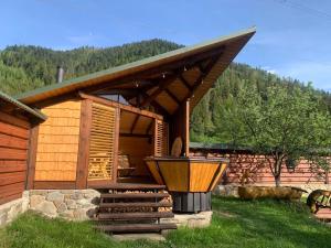 a log cabin with a porch and a grill at Садиба VAKO in Verkhniy Bystryy