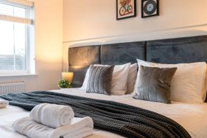 a bedroom with a large bed with towels on it at Triumph House in Hinckley