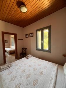a bedroom with a large bed with a wooden ceiling at Mia's Atelier in Kamária
