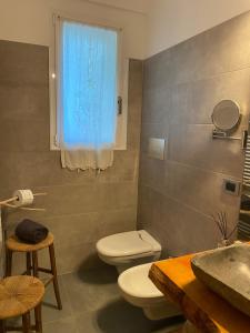 a bathroom with a toilet and a sink and a window at Xenìa in Villalago +39 photos