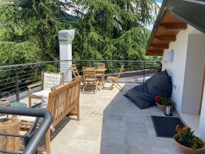 a patio with chairs and tables on a balcony at Xenìa in Villalago