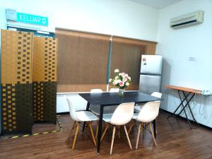 a black table with white chairs and a vase of flowers at Windsor Lane Hostel Ipoh in Ipoh