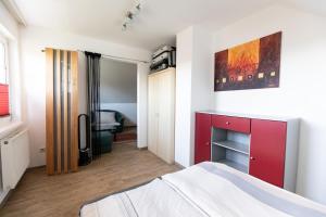 a bedroom with a bed and a red cabinet at Ferienhaus Bergblick in Redlham